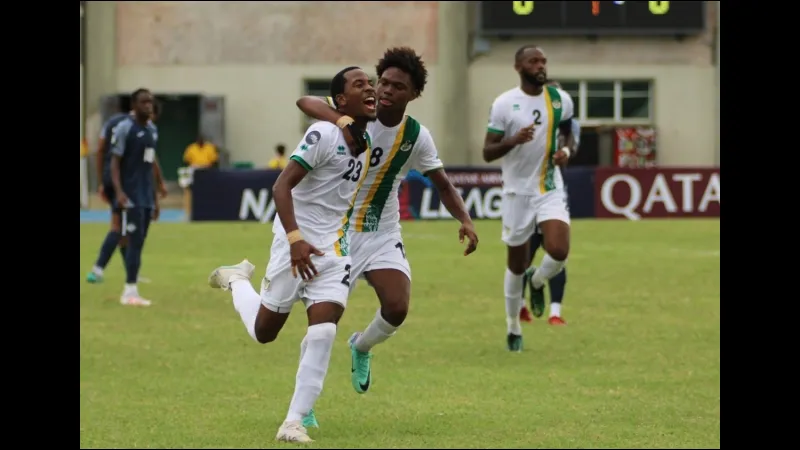 Cầu thủ Dominica và Sint Maarten tranh bóng trên sân cỏ